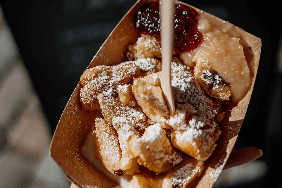 Eine Hand hält eine Schale mit Kaiserschmarrn