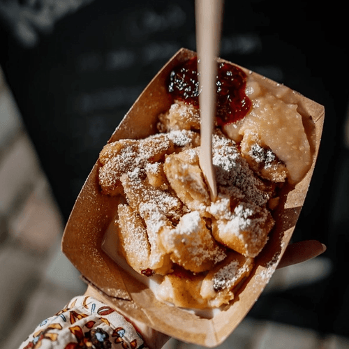 Eine Hand hält eine Schale mit Kaiserschmarrn