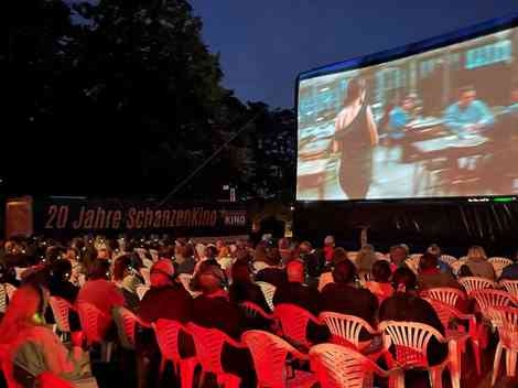 Personen beim Open-Air-Schanzen Kino auf Plastikstühlen