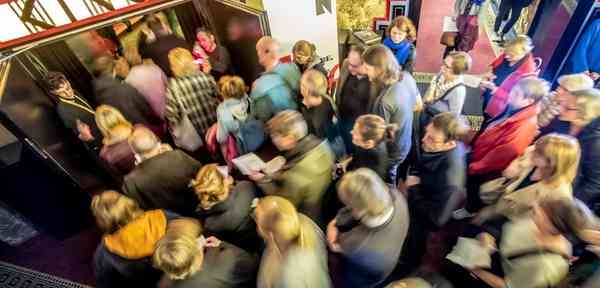 Vogelperspektive auf Menschen, die ins Passage Kino strömen