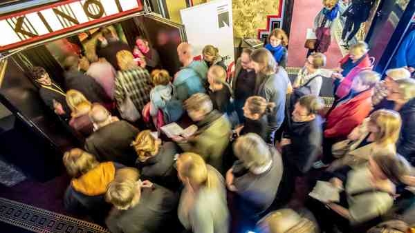 Vogelperspektive auf Menschen, die ins Passage Kino strömen