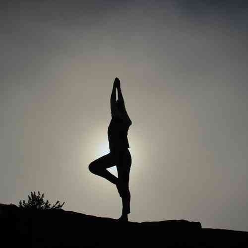 Eine Person macht Yoga vor der Sonne