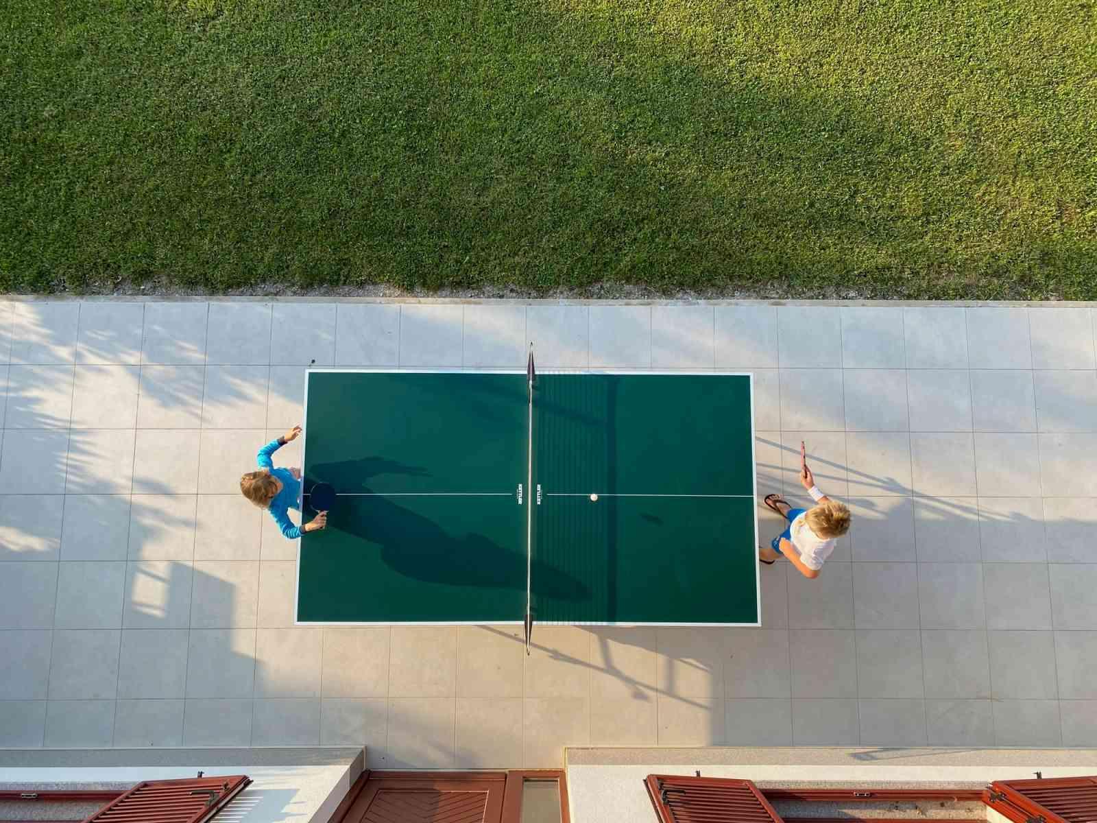 Zwei Personen spielen an einer Tischtennis Platte