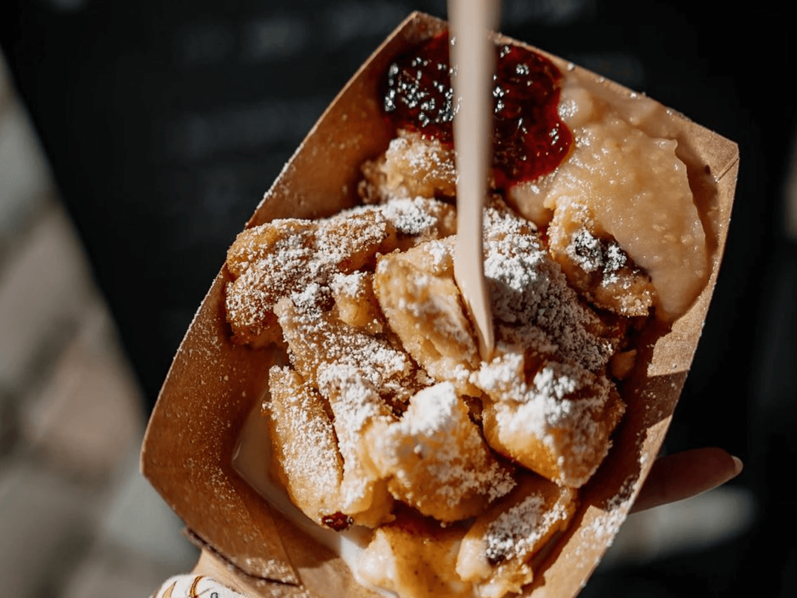 Eine Hand hält eine Schale mit Kaiserschmarrn