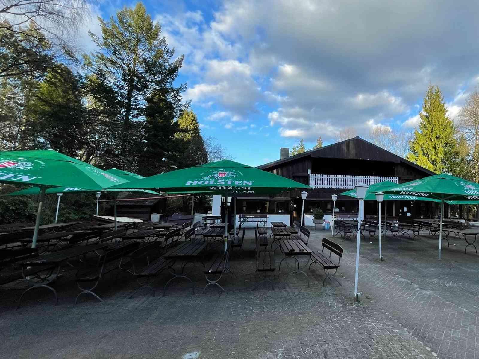 Biergarten mit Bänken, Tischen und Sonnenschirmen