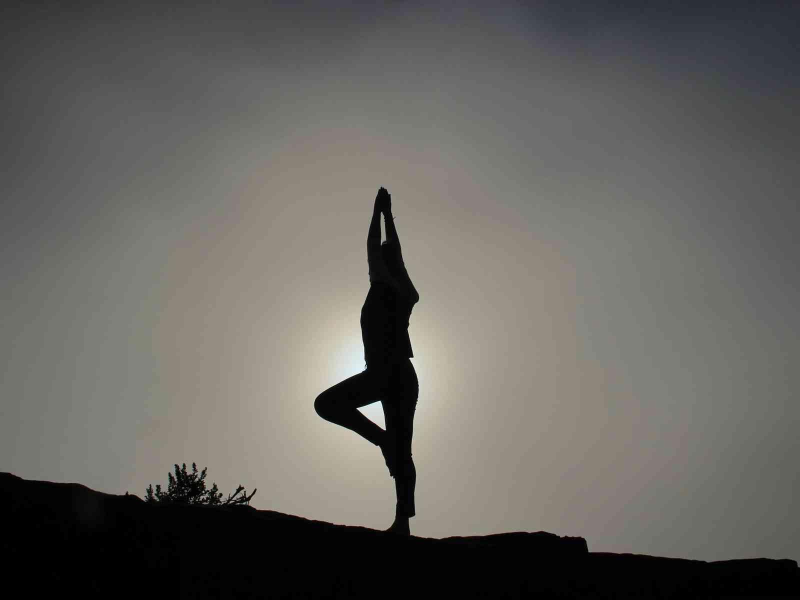 Eine Person macht Yoga vor der Sonne