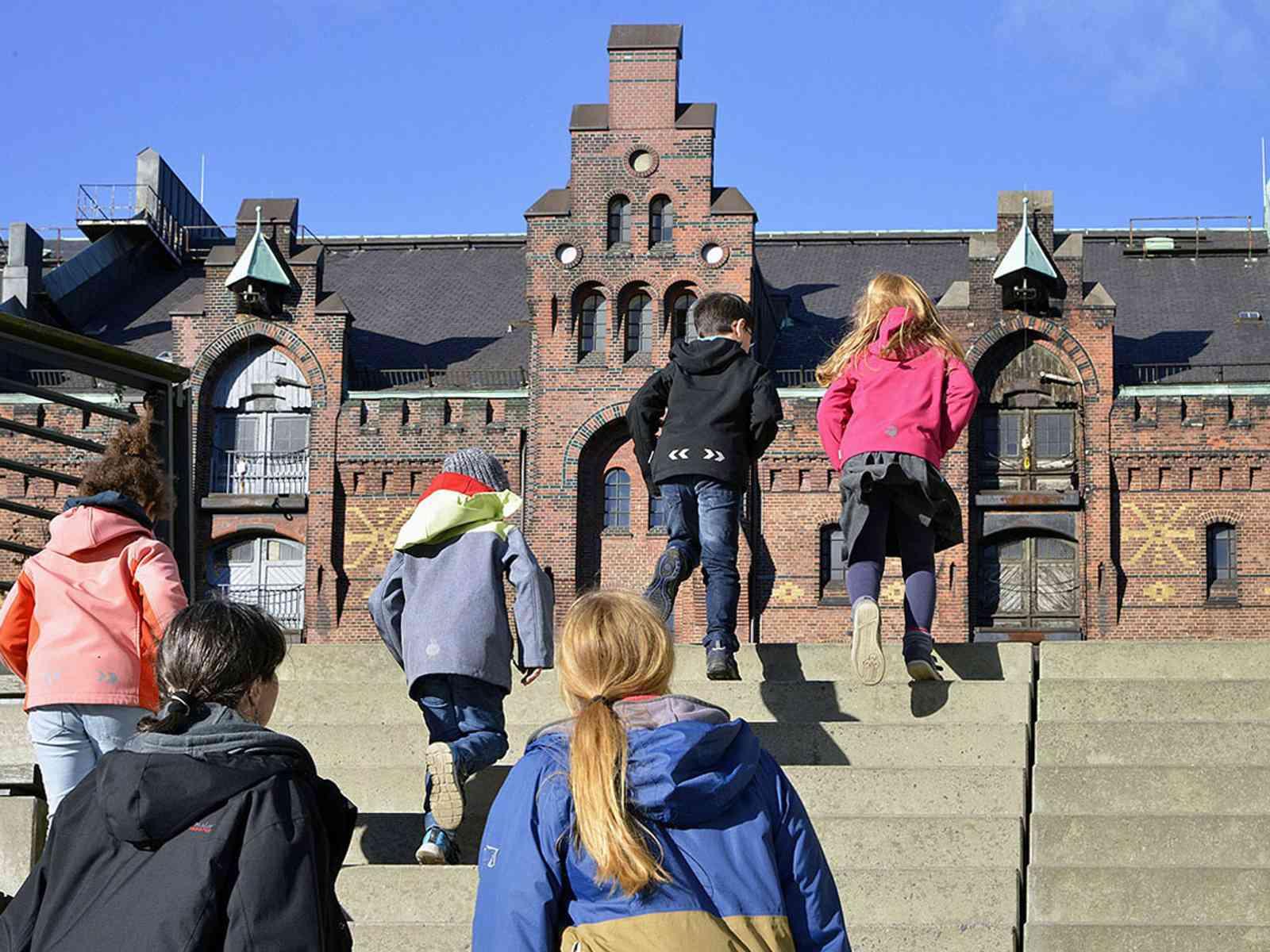 Kinder laufen Treppenstufen hinauf