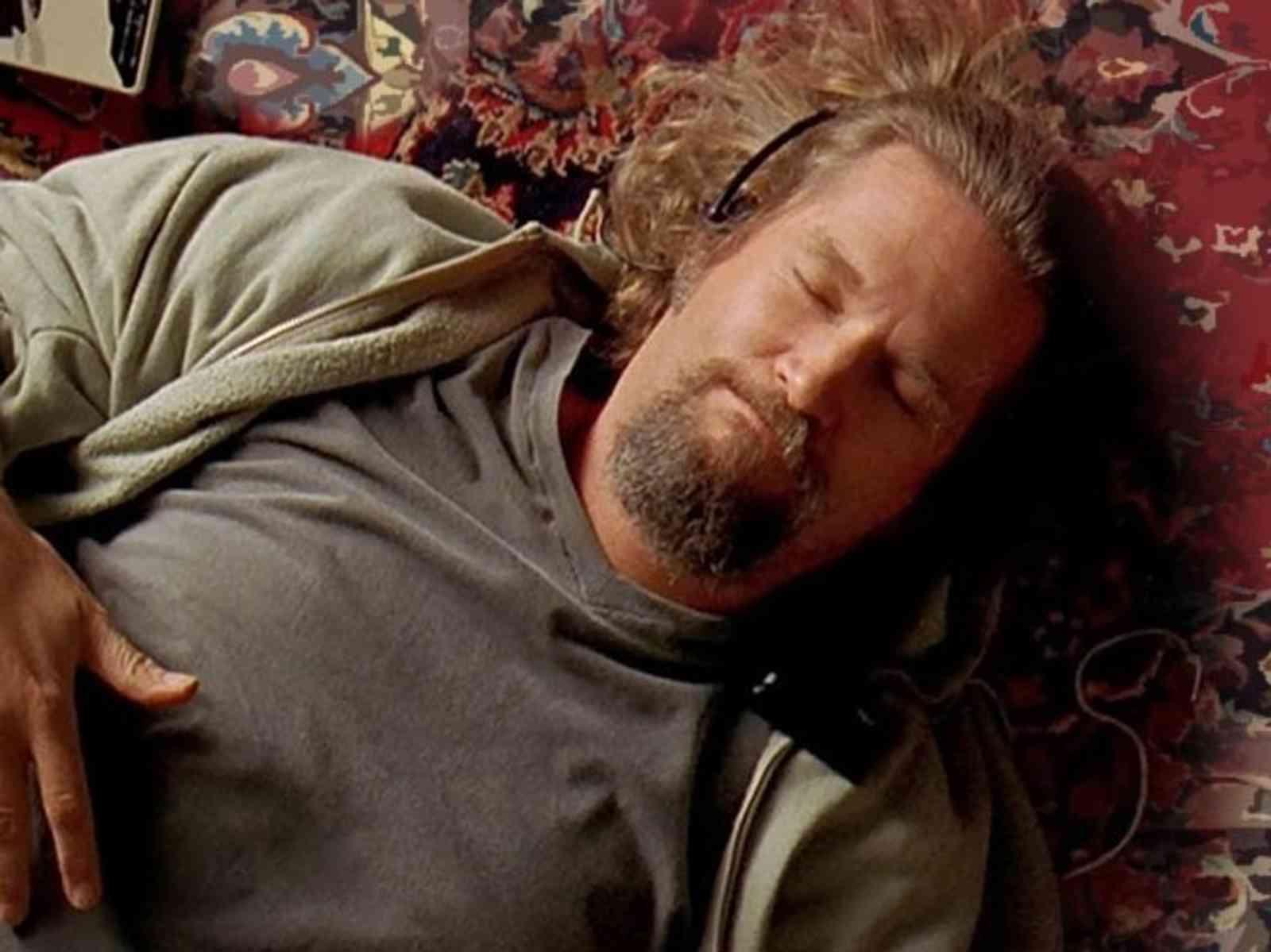 Jeff Bridges liegt mit Kopfhörern und geschlossenen Augen auf einem Teppich.