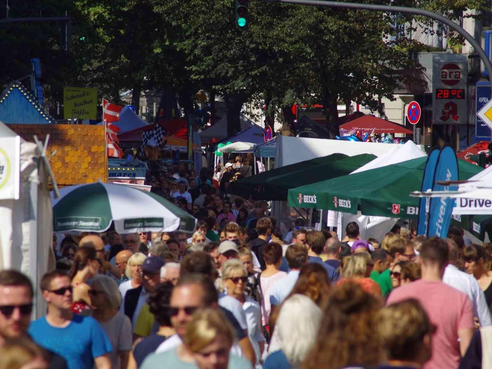 Eine volle Straße mit Schirmen und Zelten