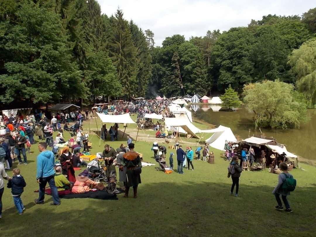 Personen in Verkleidung auf einer Wiese mit Zelten
