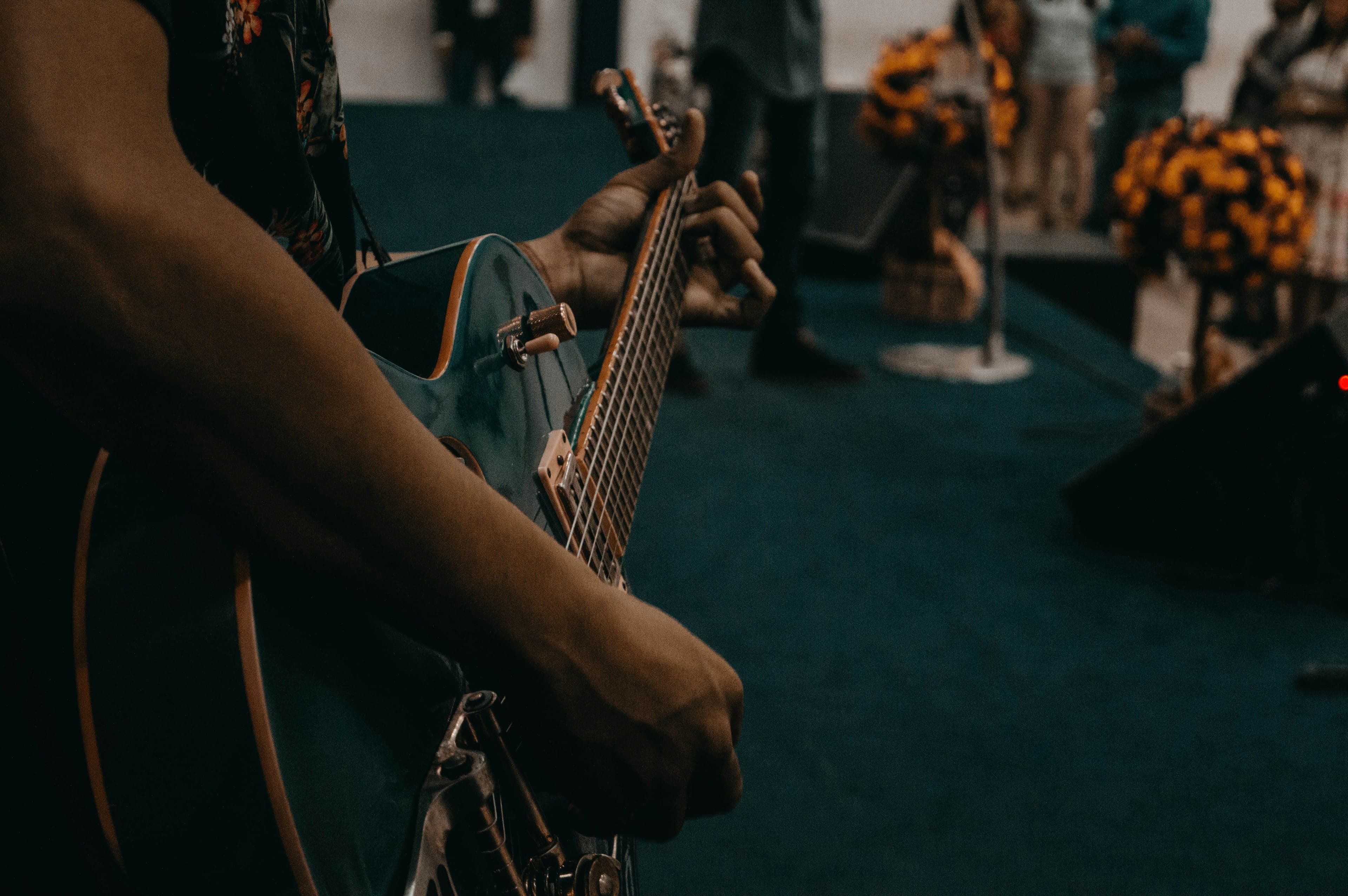 Gitarre in der Hand eines Musikers auf einer Bühne