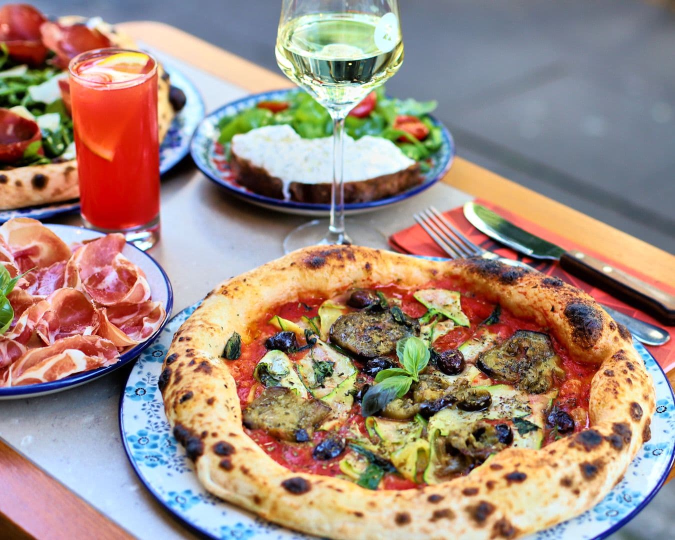 Pizza und Wein angerichtet auf einem Tisch