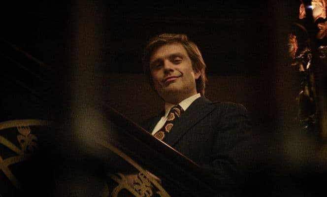 Der Schauspieler Sebastian Stan steht in seiner Rolle als Donald Trump auf einer Treppe und schaut in die Kamera