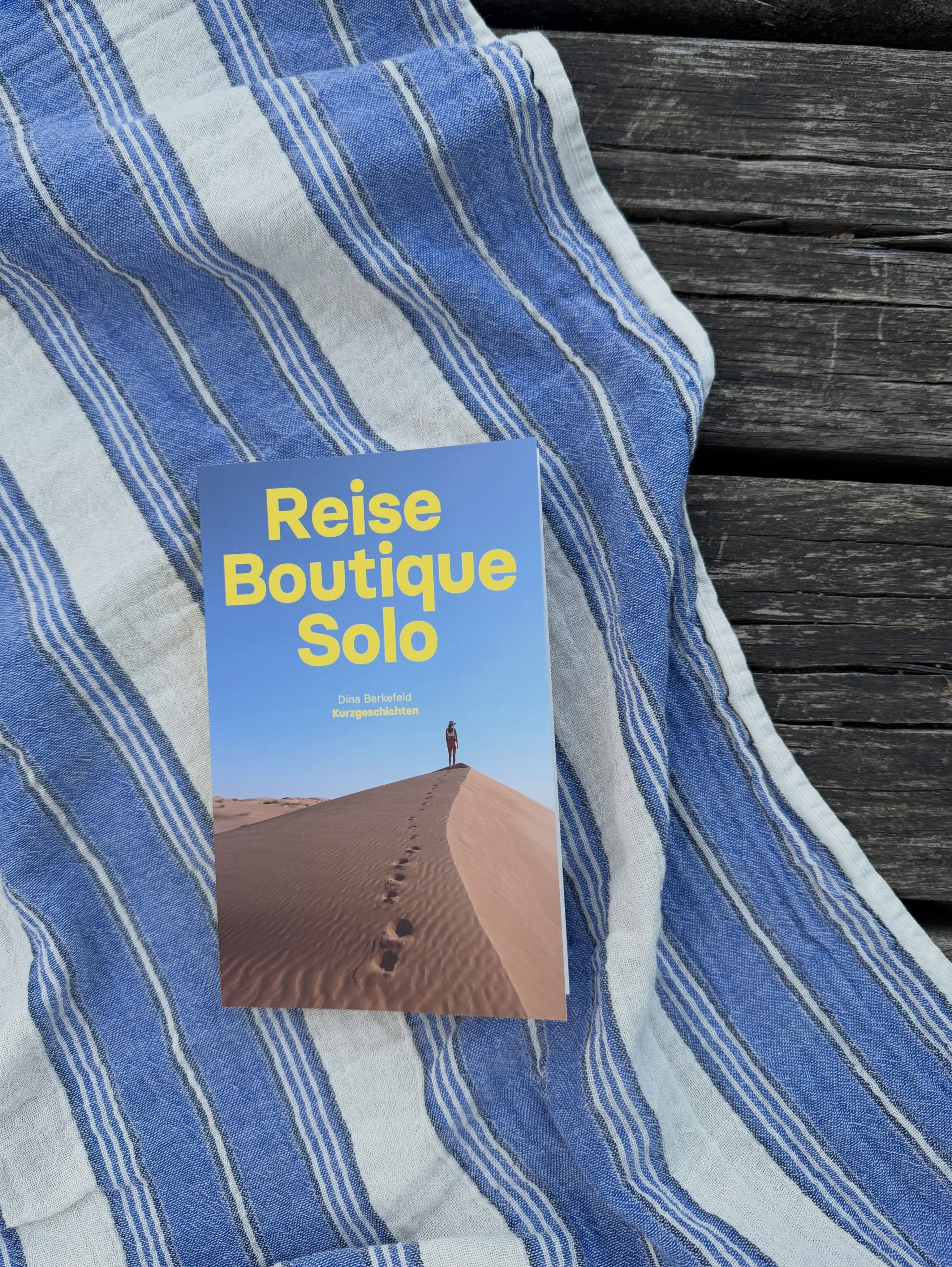 Dina Berkefelds Buch "Reise Boutique Solo" liegt auf einem Handtuch