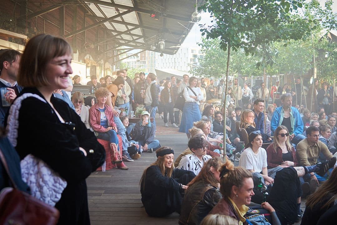 Viele Menschen stehen und sitzen auf dem Boden