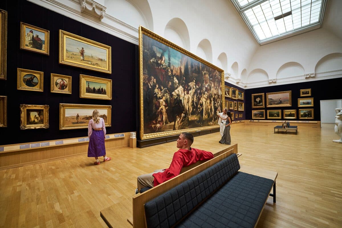 Eine Person sitzt auf einer Bank mitten in einem Ausstellungssaal der Hamburger Kunsthalle