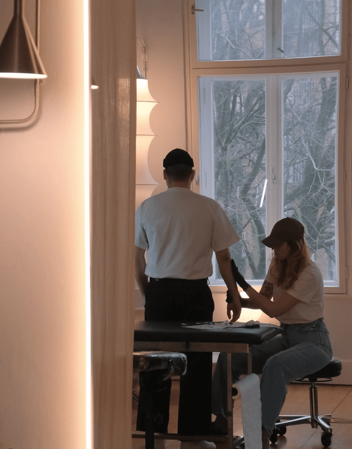 Eine Frau tätowiert den Arm eines Mannes