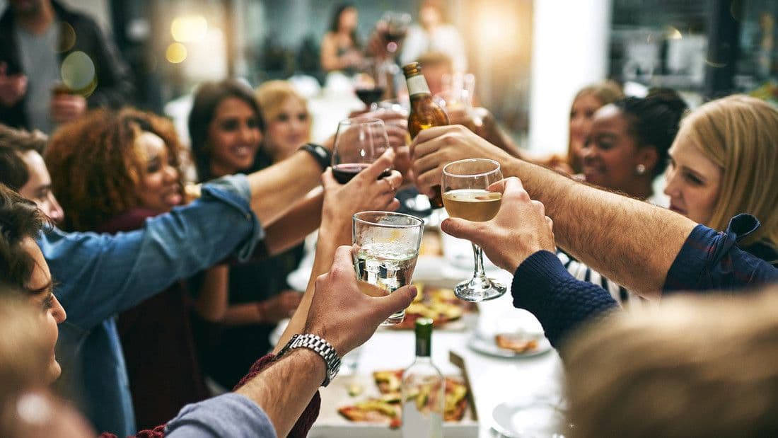 Viele Menschen prosten mit Wein an