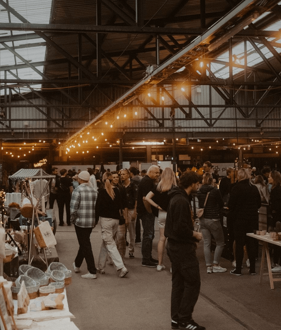 Menschen stöbern auf dem Markt der Møglichkeiten