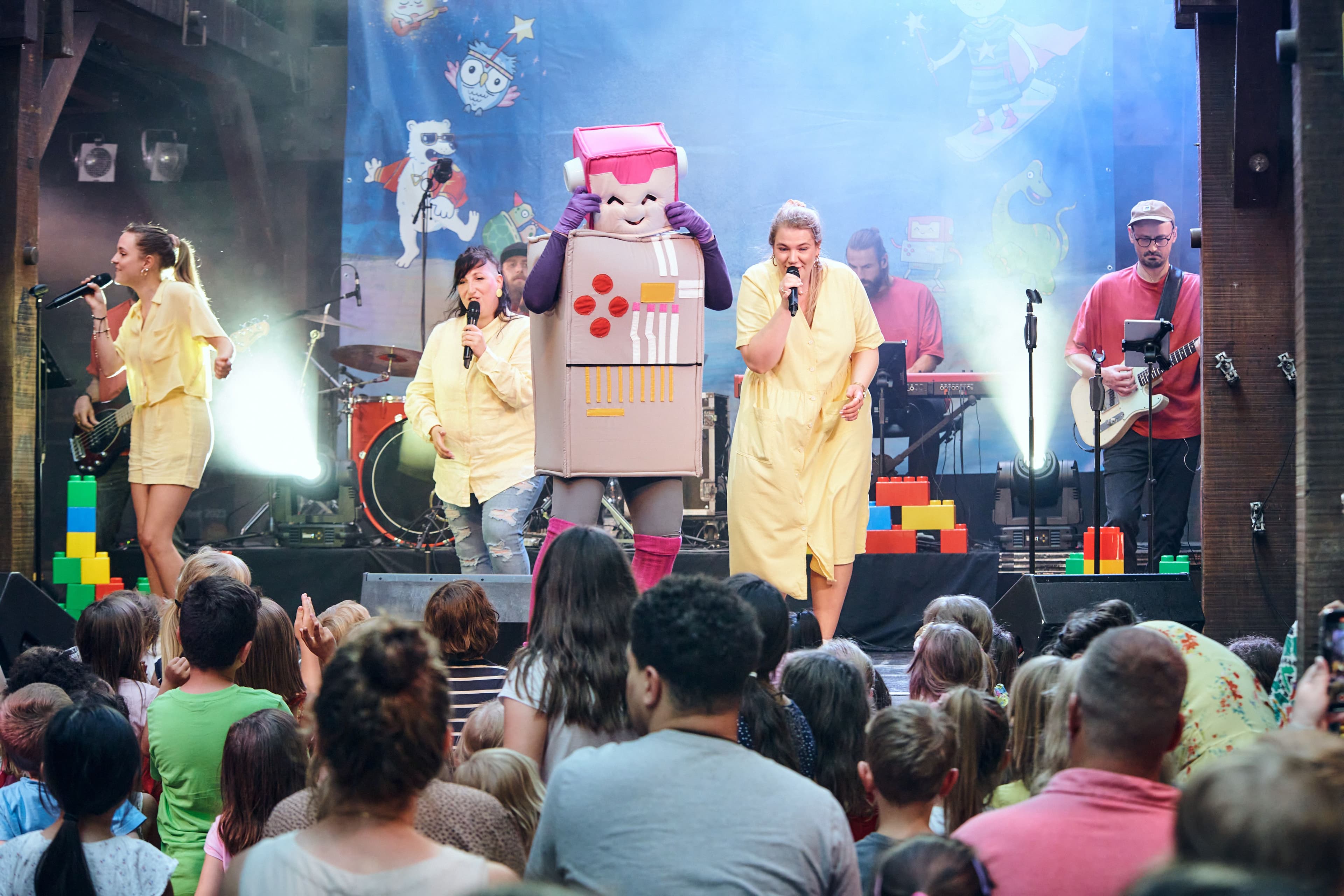 Personen singen auf einer Bühne für das Publikum
