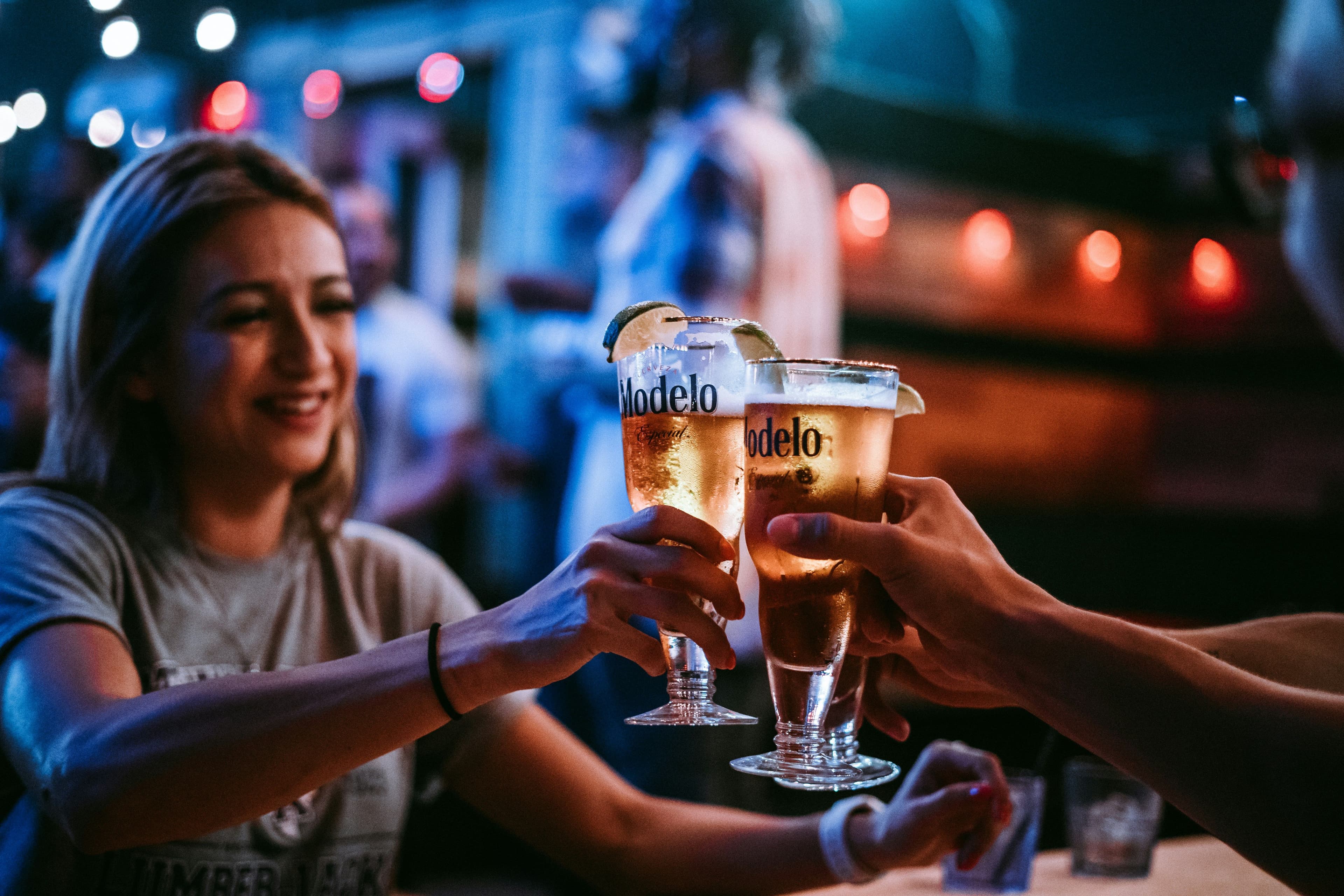 Drei anstoßende Menschen in einer Bar