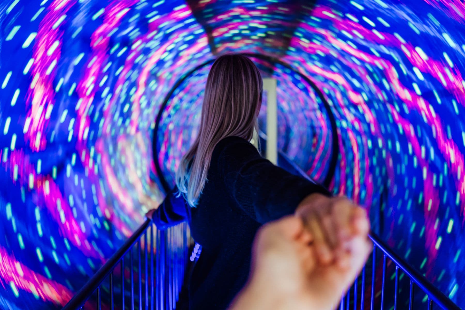 Eine Person beschreitet einen Tunnel voller Lichtsprenkel.