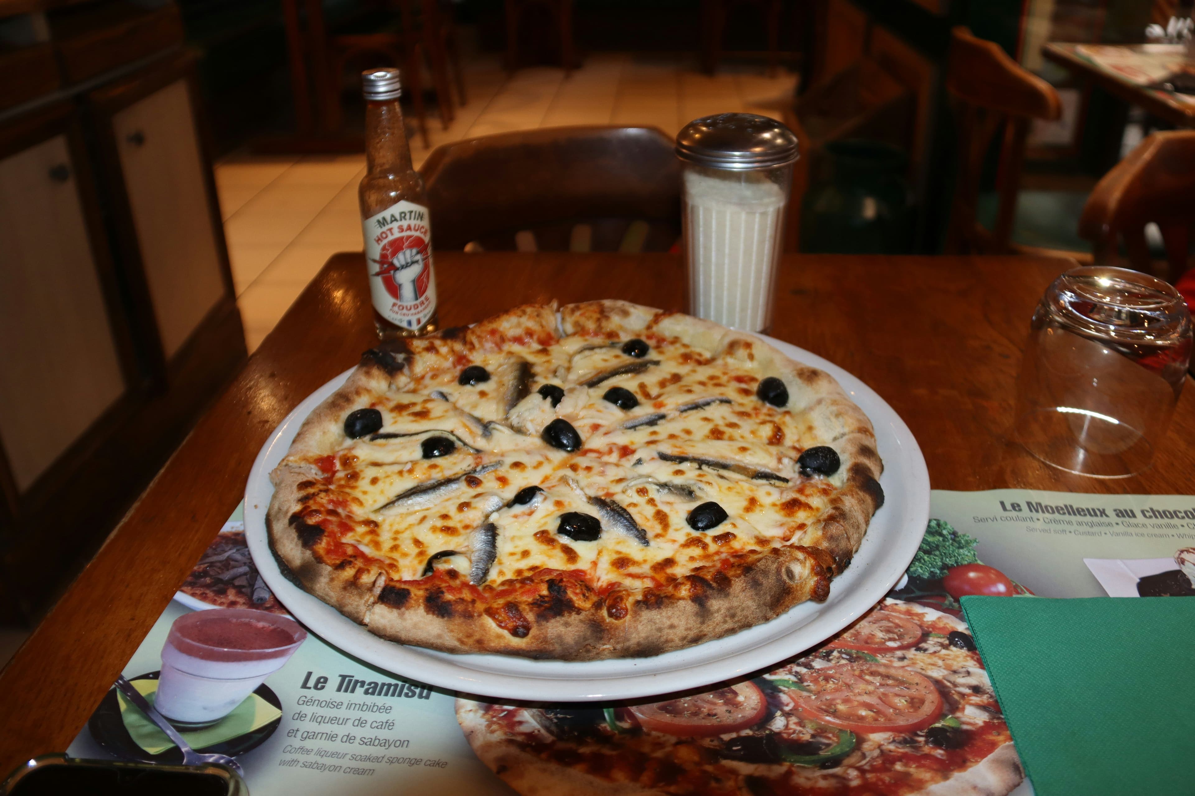 Pizza mit Sardellen und Oliven auf einem Teller