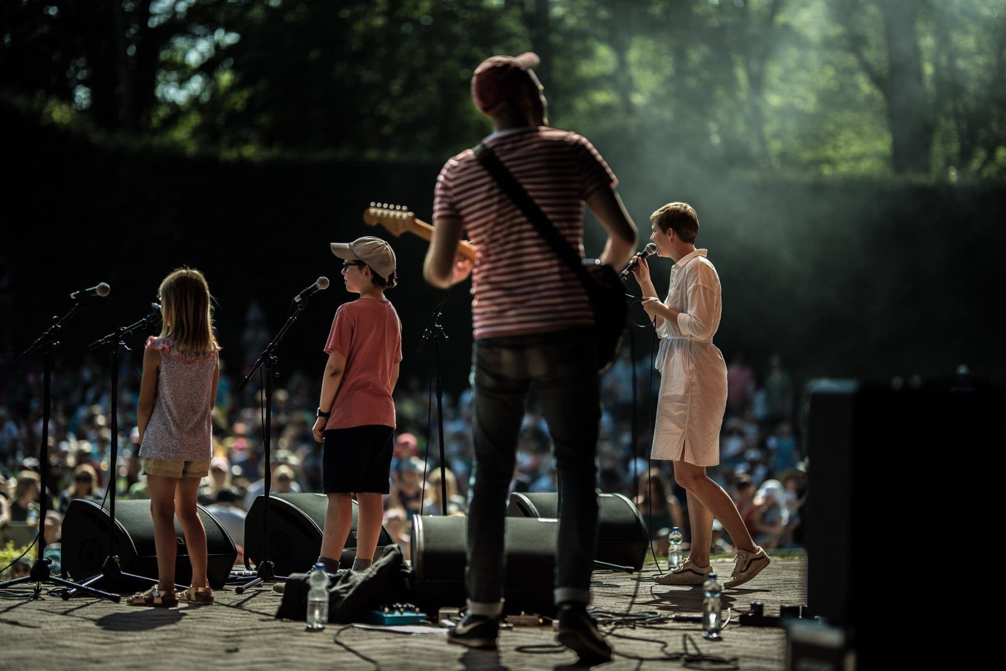Bei Lütt im Park singen Musiker:innen mit Kindern auf einer Bühne.