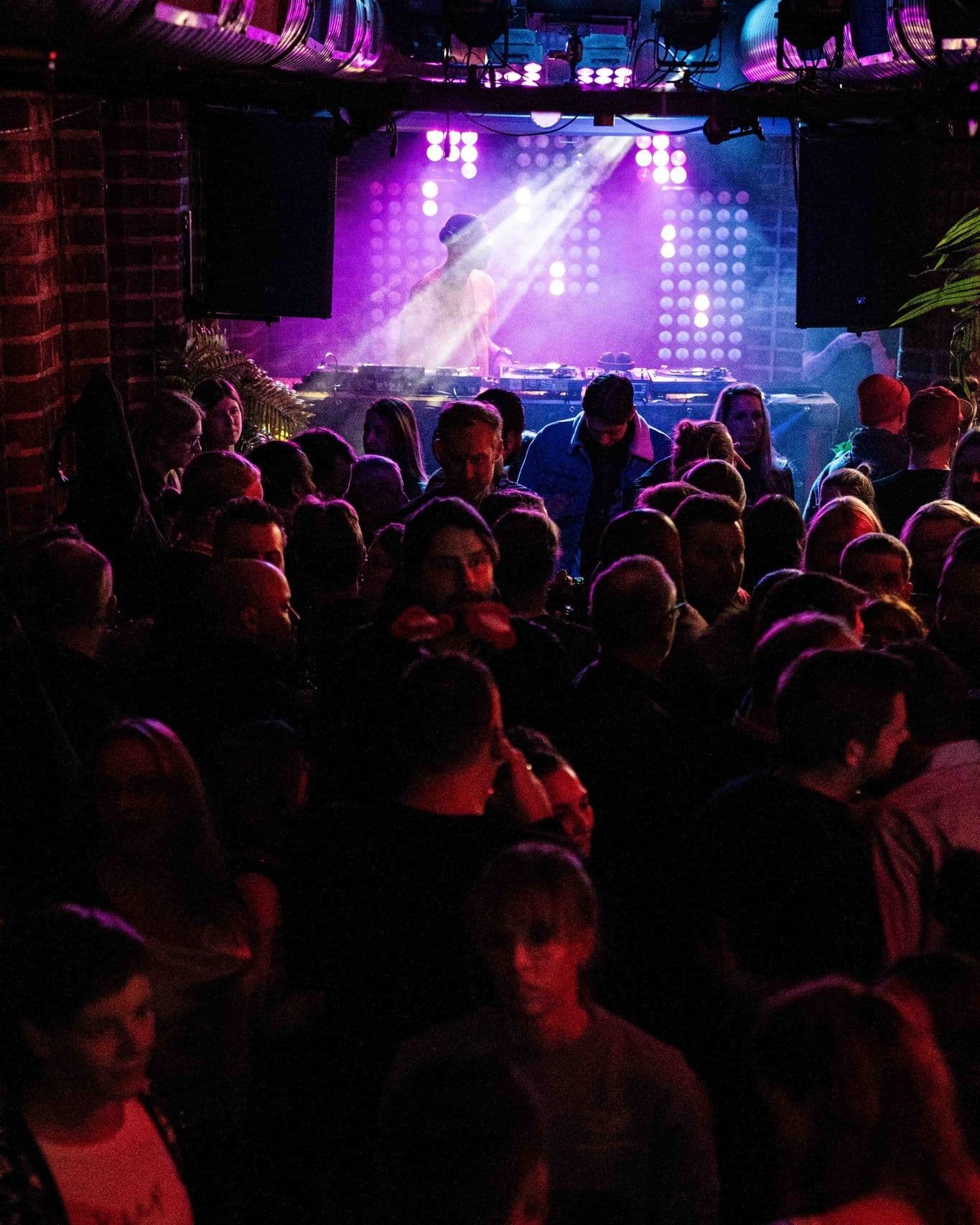 Volle Tanzfläche mit DJ-Pult im Freundlich + Kompetent