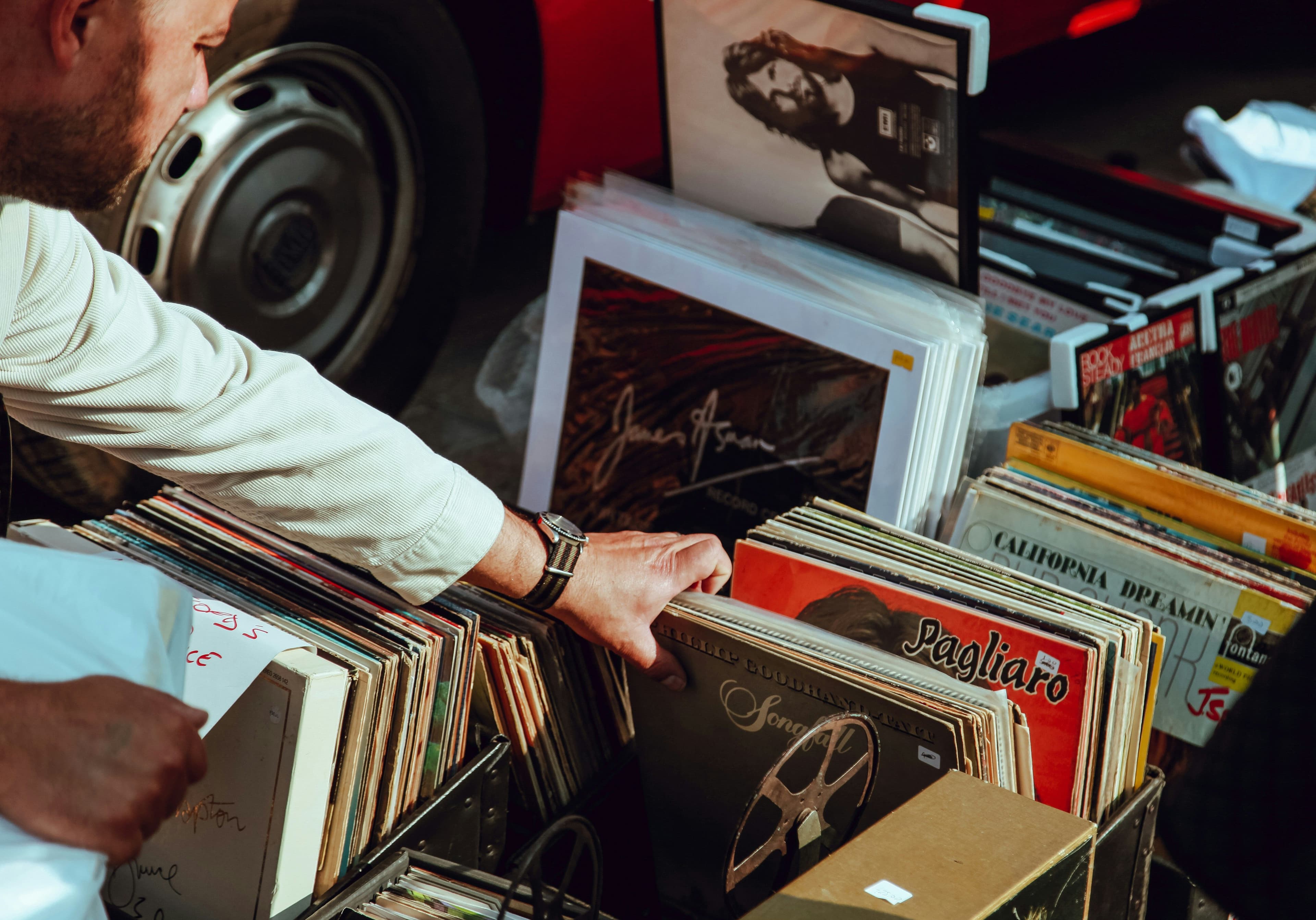 Person schaut sich Vinyls auf einem Flohmarkt an