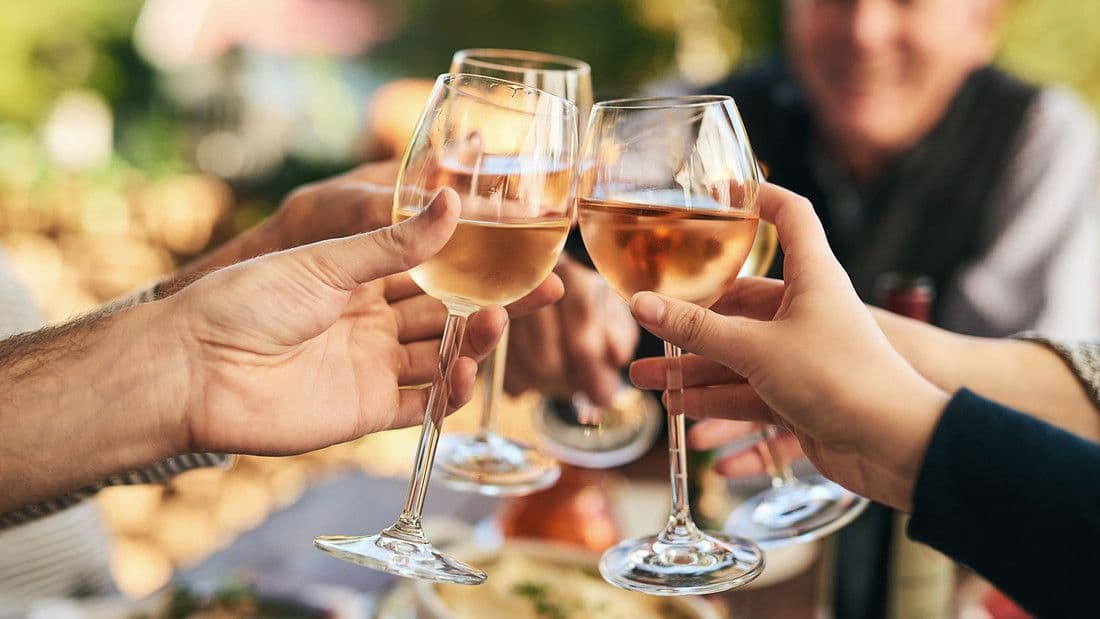 Einige Menschen stoßen mit Wein an