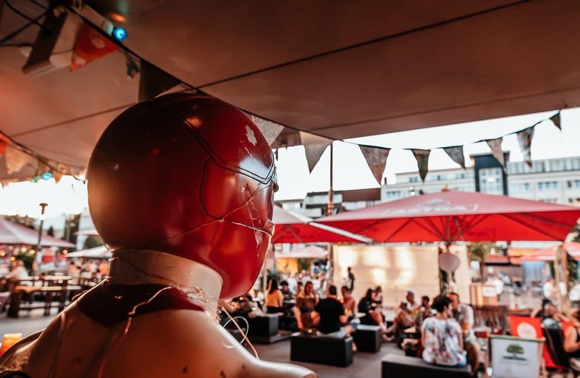 Person mit Helm vor dem Außenbereich des Sommersalons.