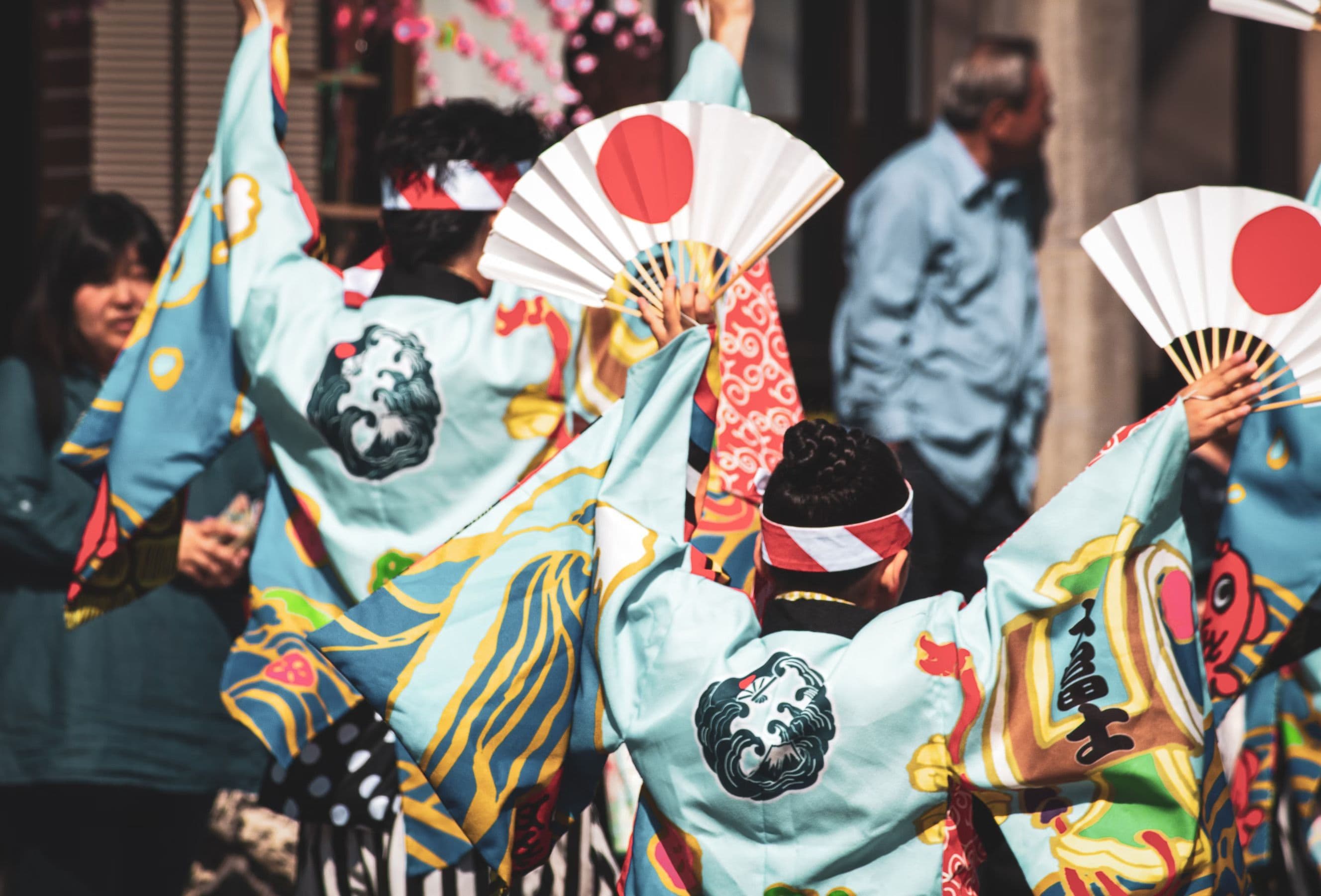 Menschen halten japanische Fächer in die Luft.
