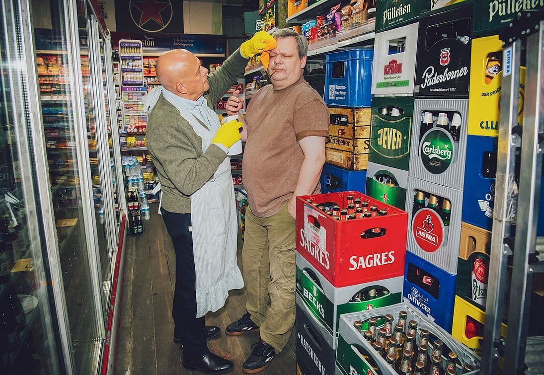 Zwei Darsteller:innen in einem Getränkemarkt