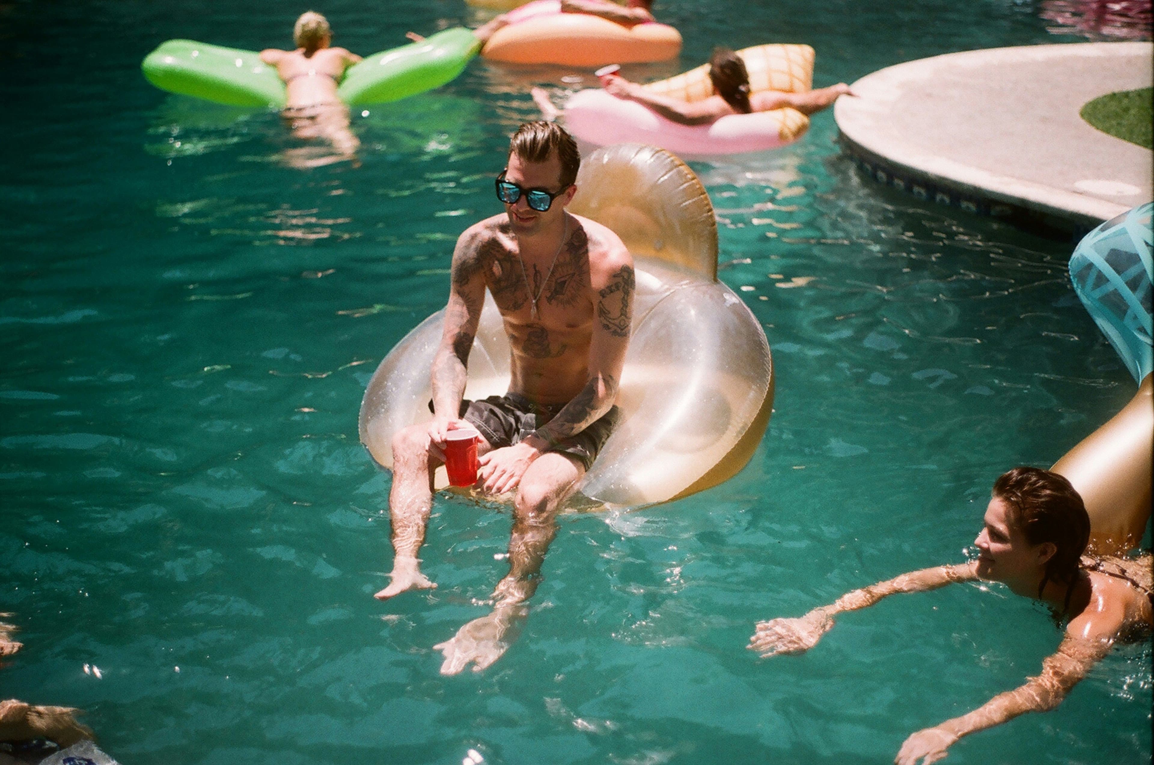 Badegäste mit aufblasbaren Donuts