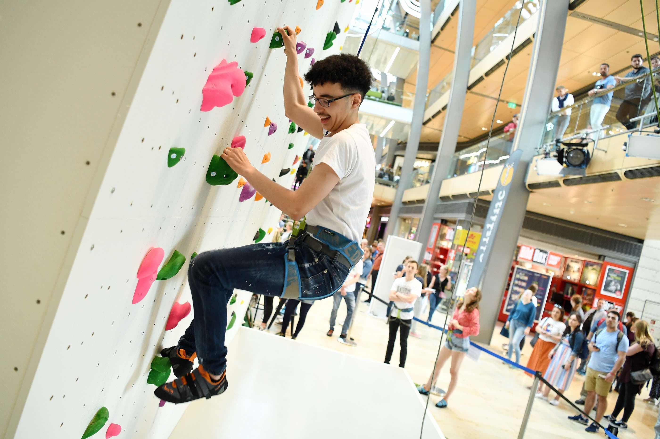 Ein Junge klettert an einer Kletterwand in der Europa-Passage