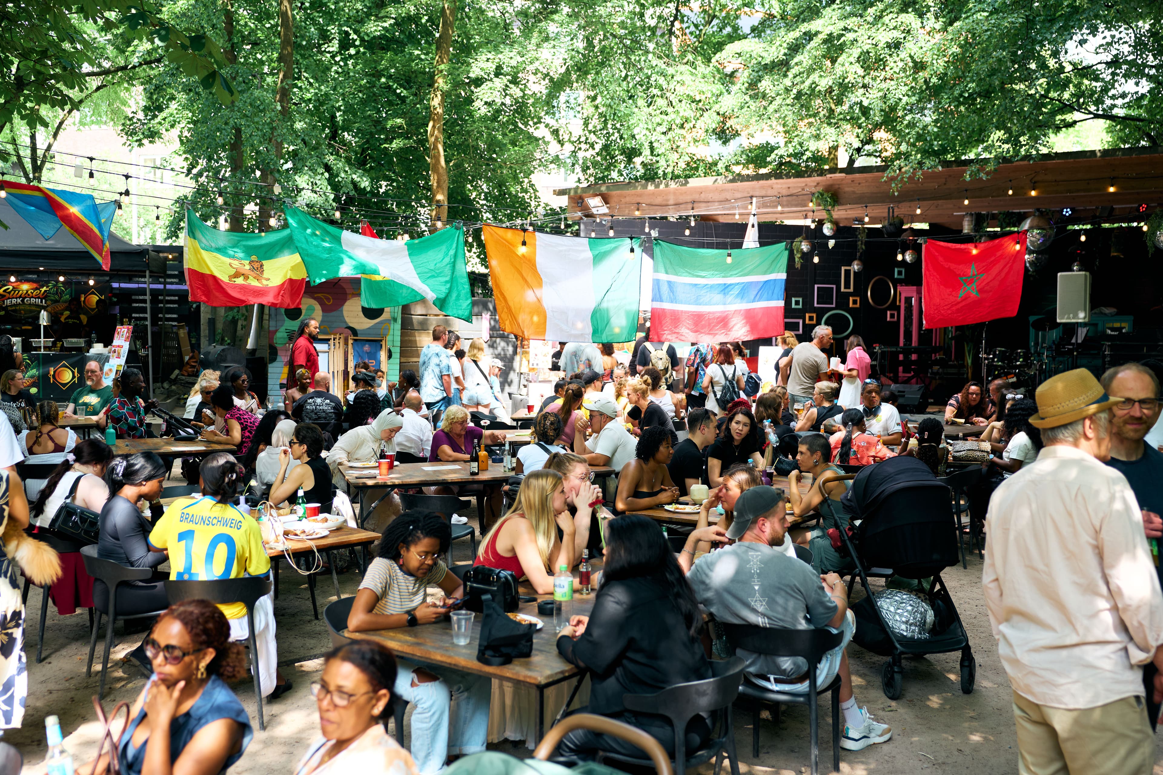 Menschen sitzen an Tischen beim Food Festival
