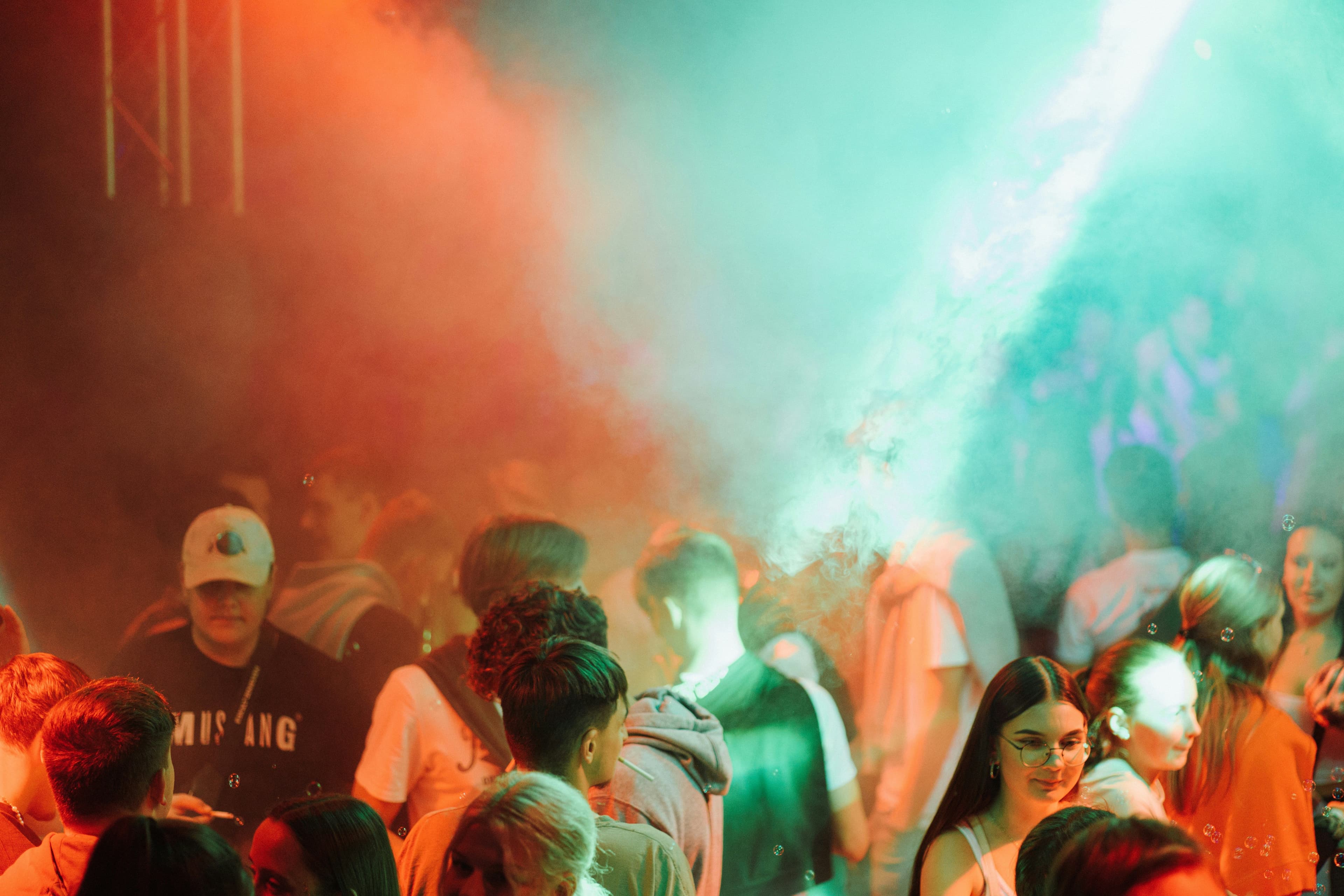 Besucher:innen in einem Club mit Nebel