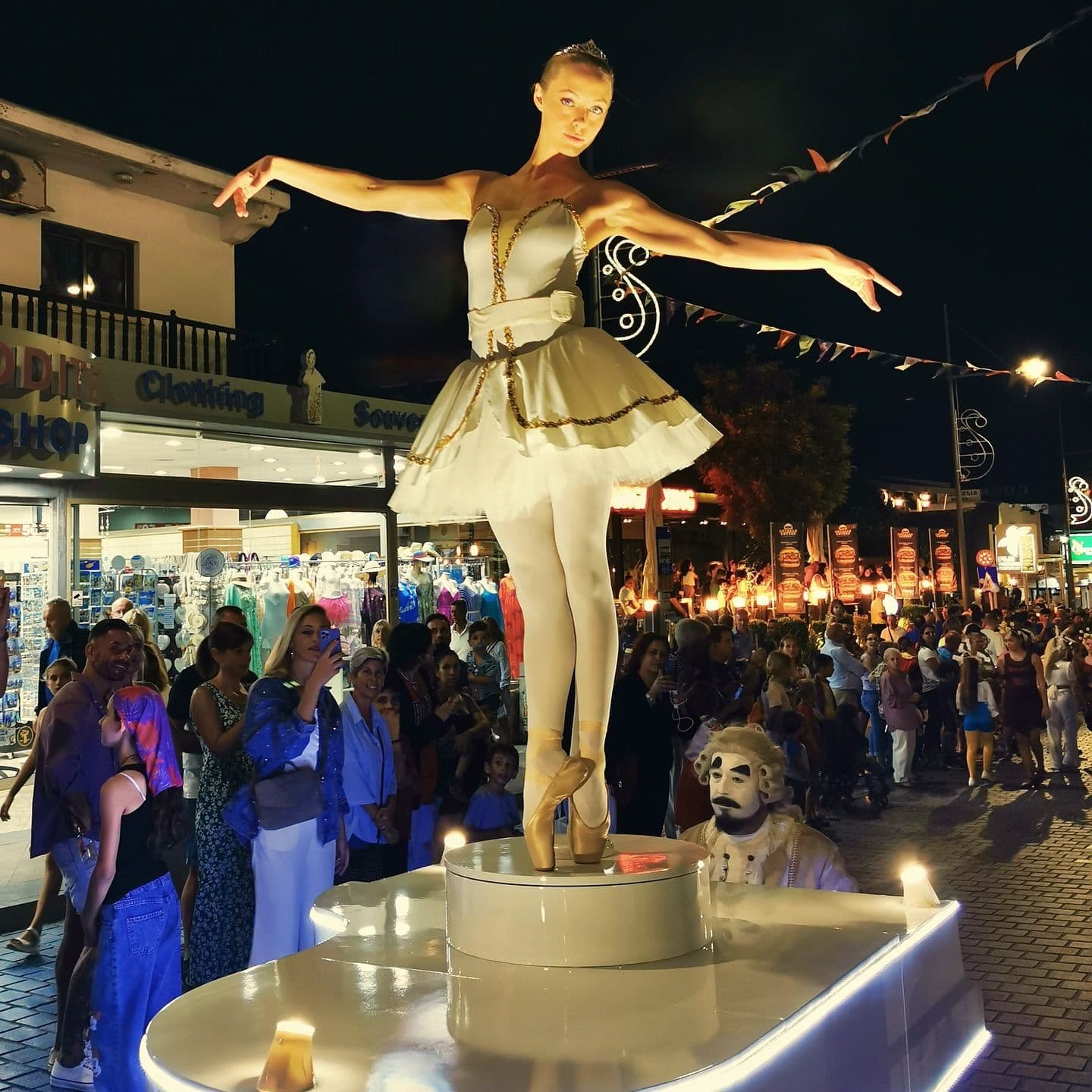 Menschen stehen auf der Straße um eine Ballerina herum