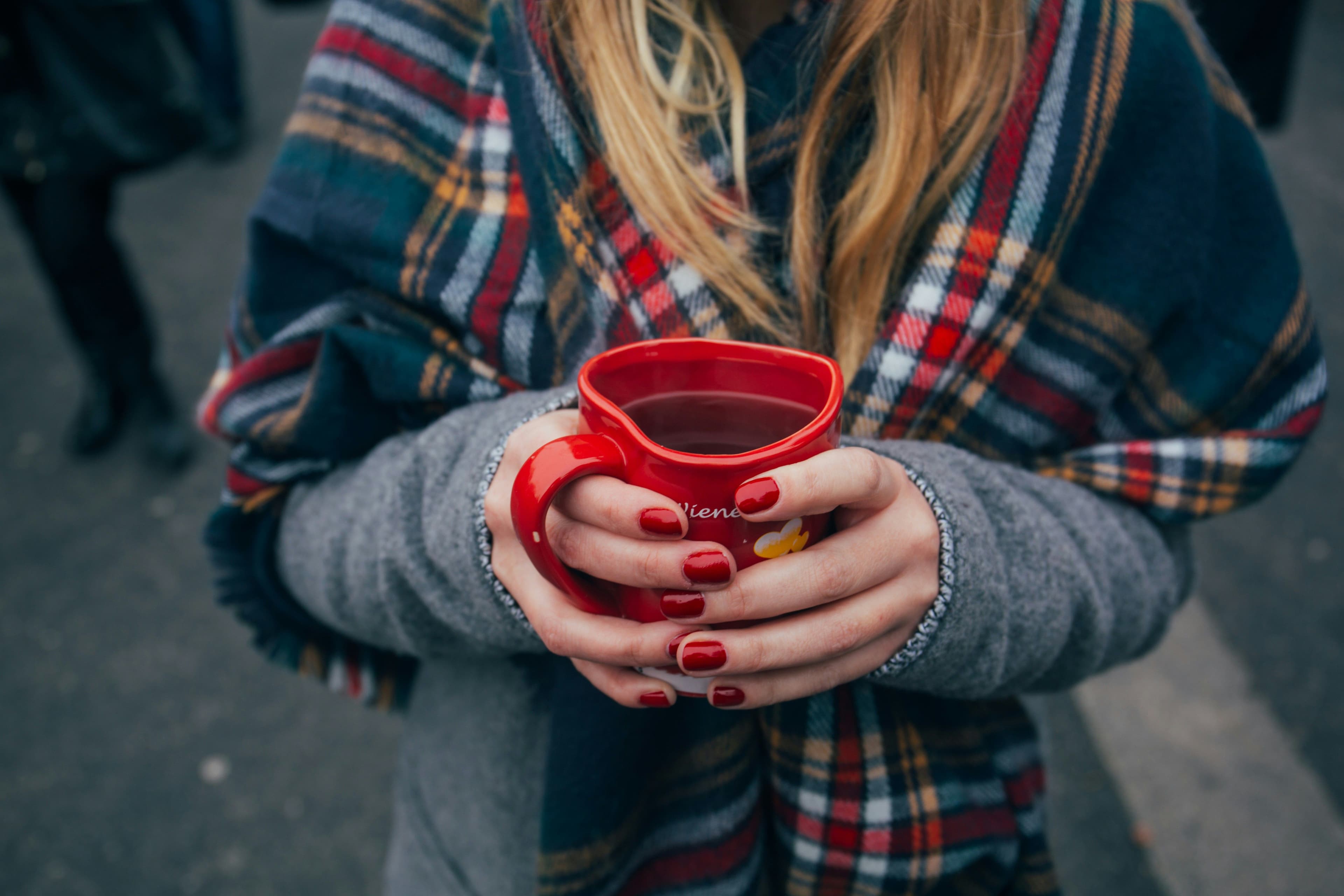 Eine Frau hält eine Tasse Glühwein in den Händen
