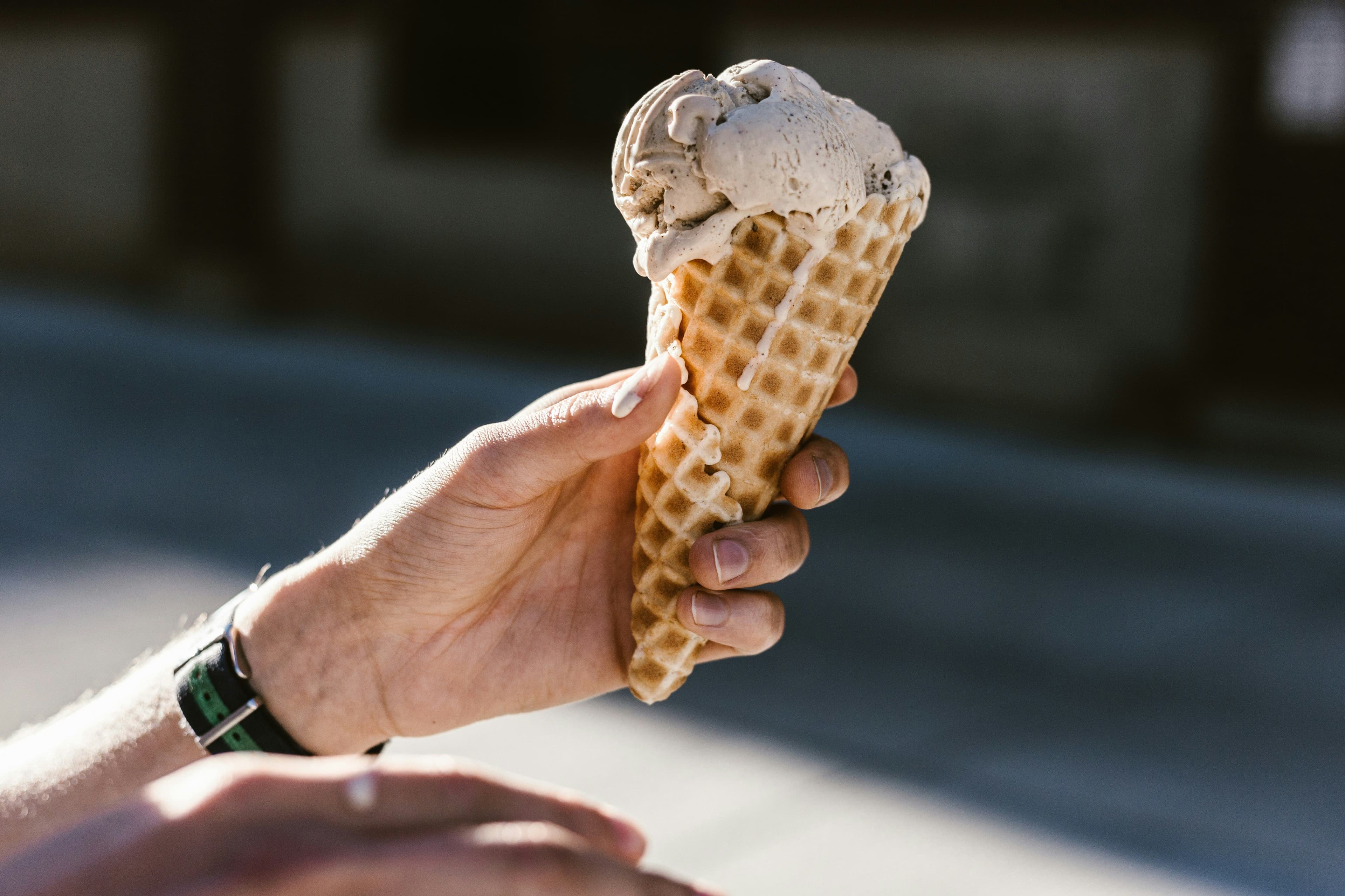Hand hält Eiswaffel mit Eiskugel