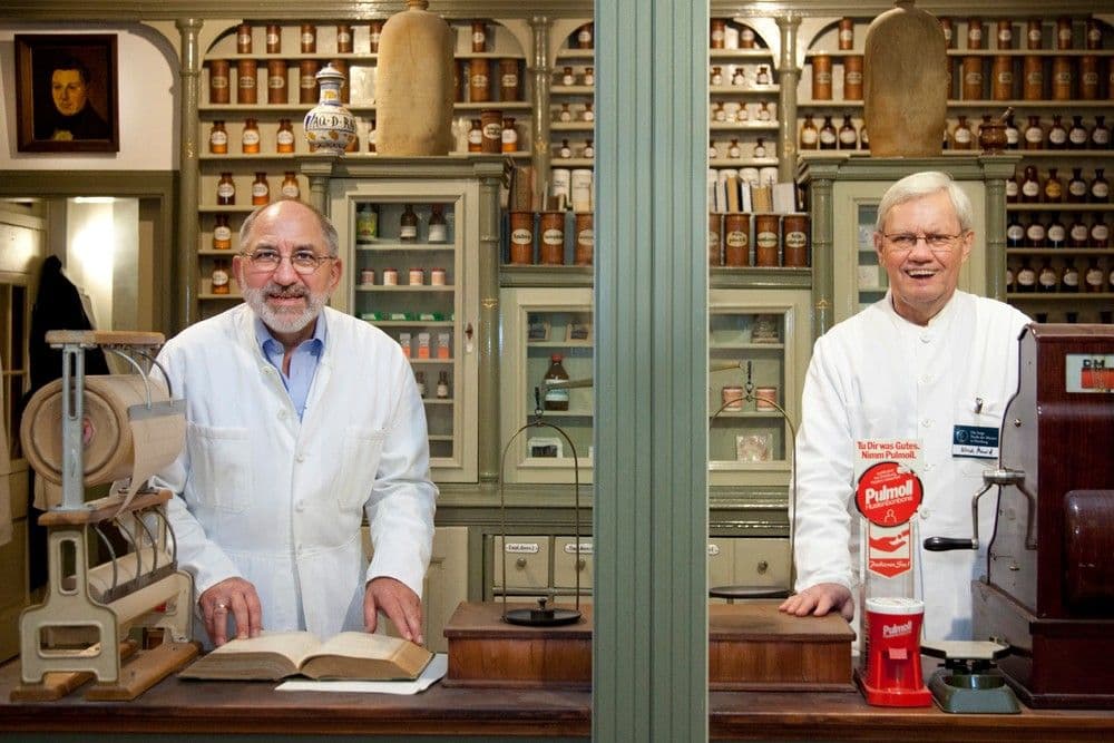 Zwei Apotheker hinter einer Scheibe