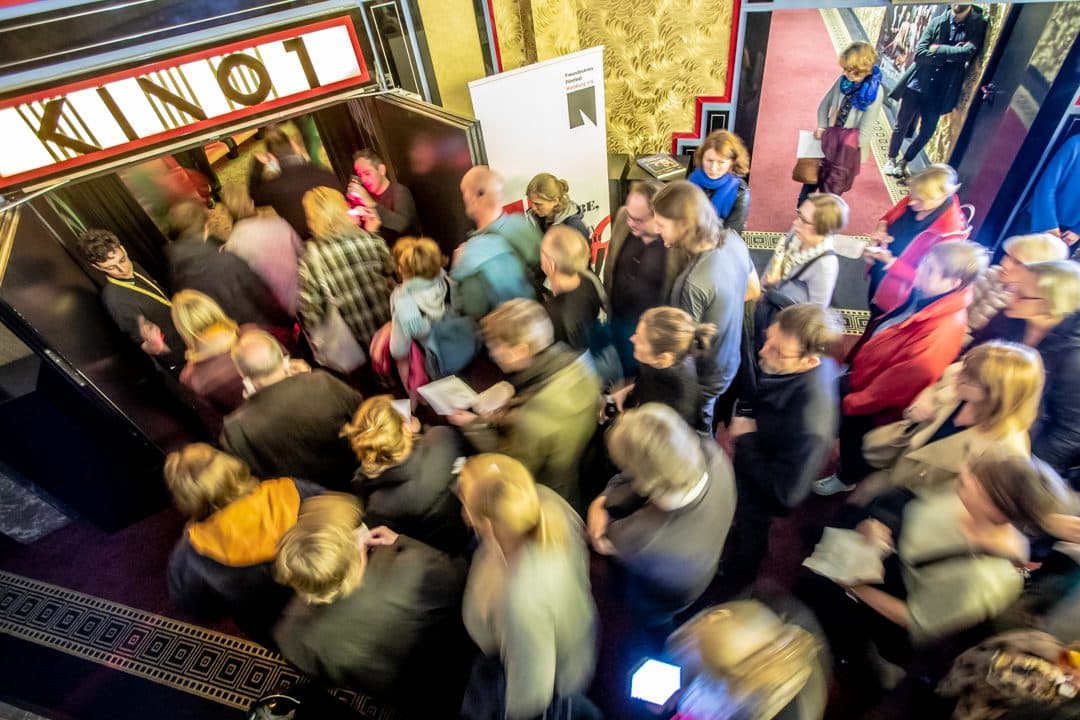 Menschen stehen Schlage vor einem Kinosaal