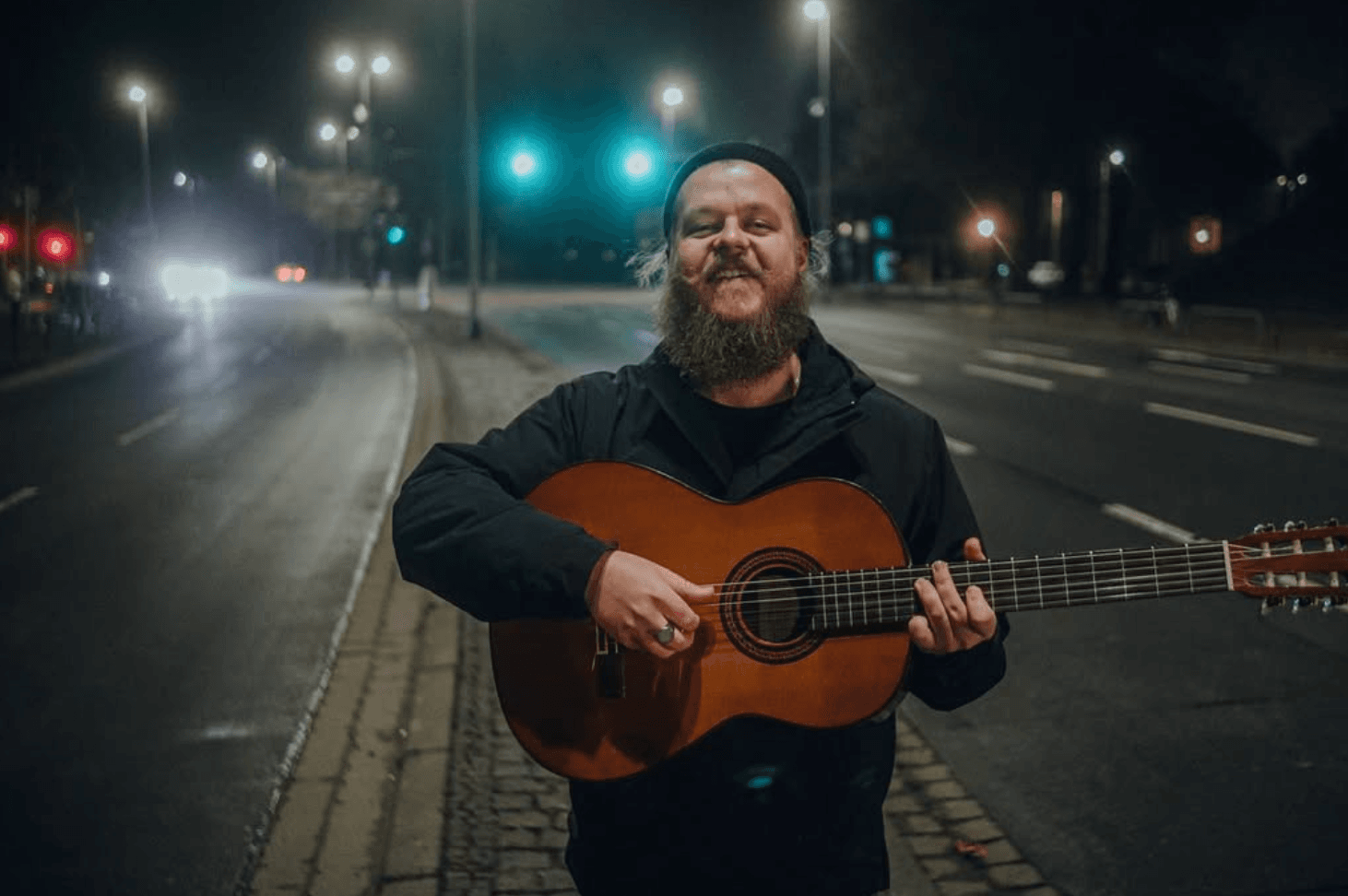 Lukas Dolphin steht mit seiner Gitarre auf der Straße