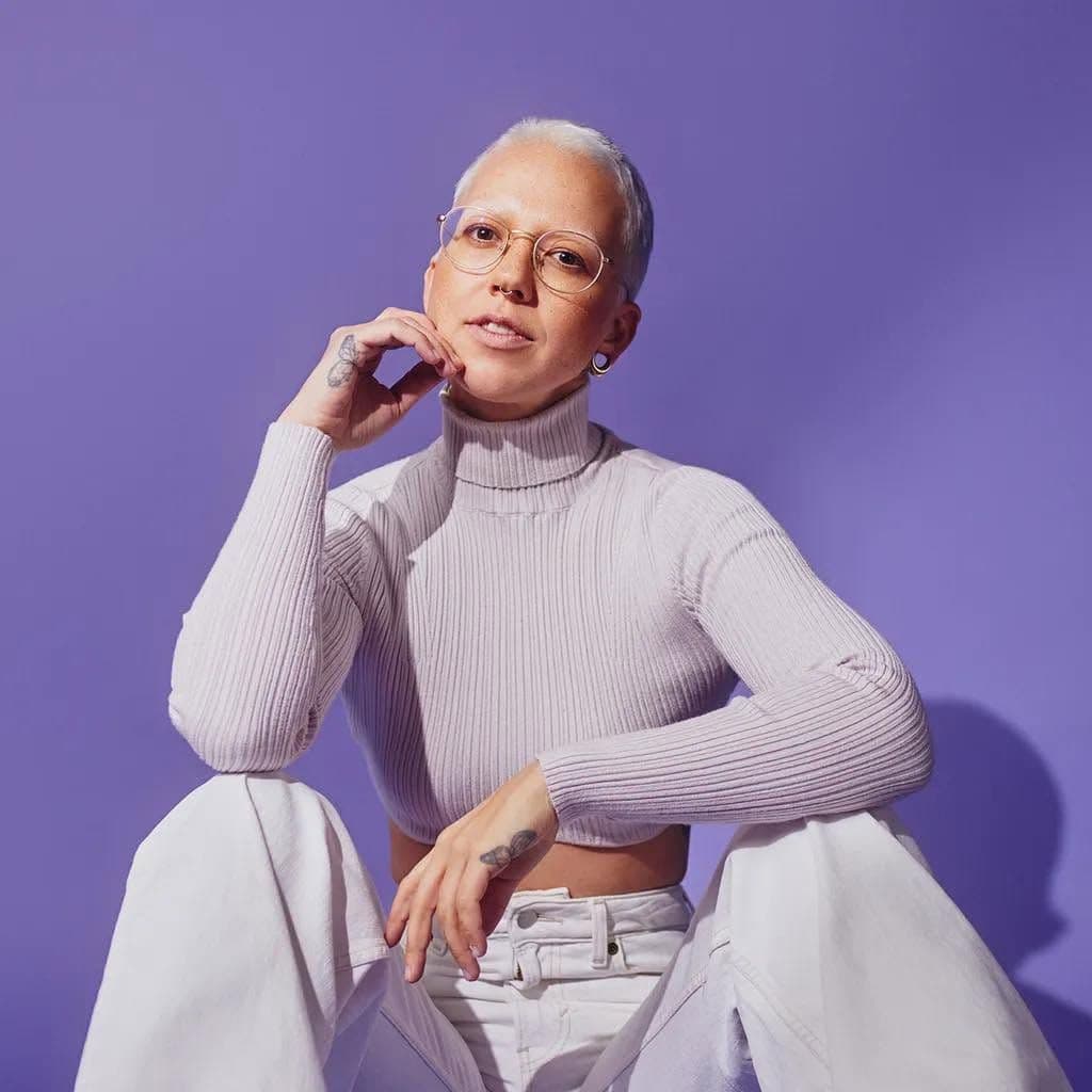 Stefanie Heinzmann sitzt vor einer lila Wand