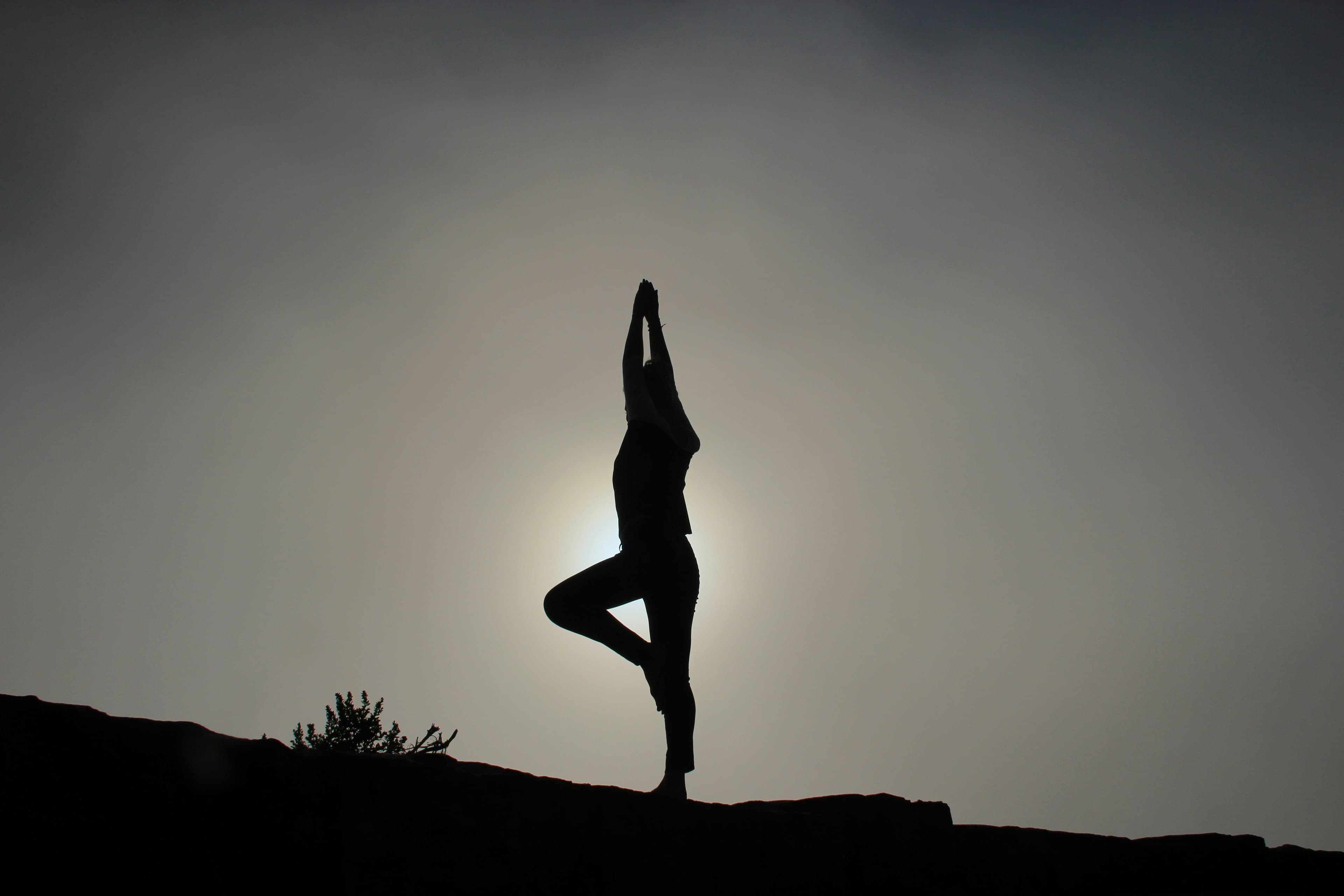 Eine Person macht Yoga vor der Sonne