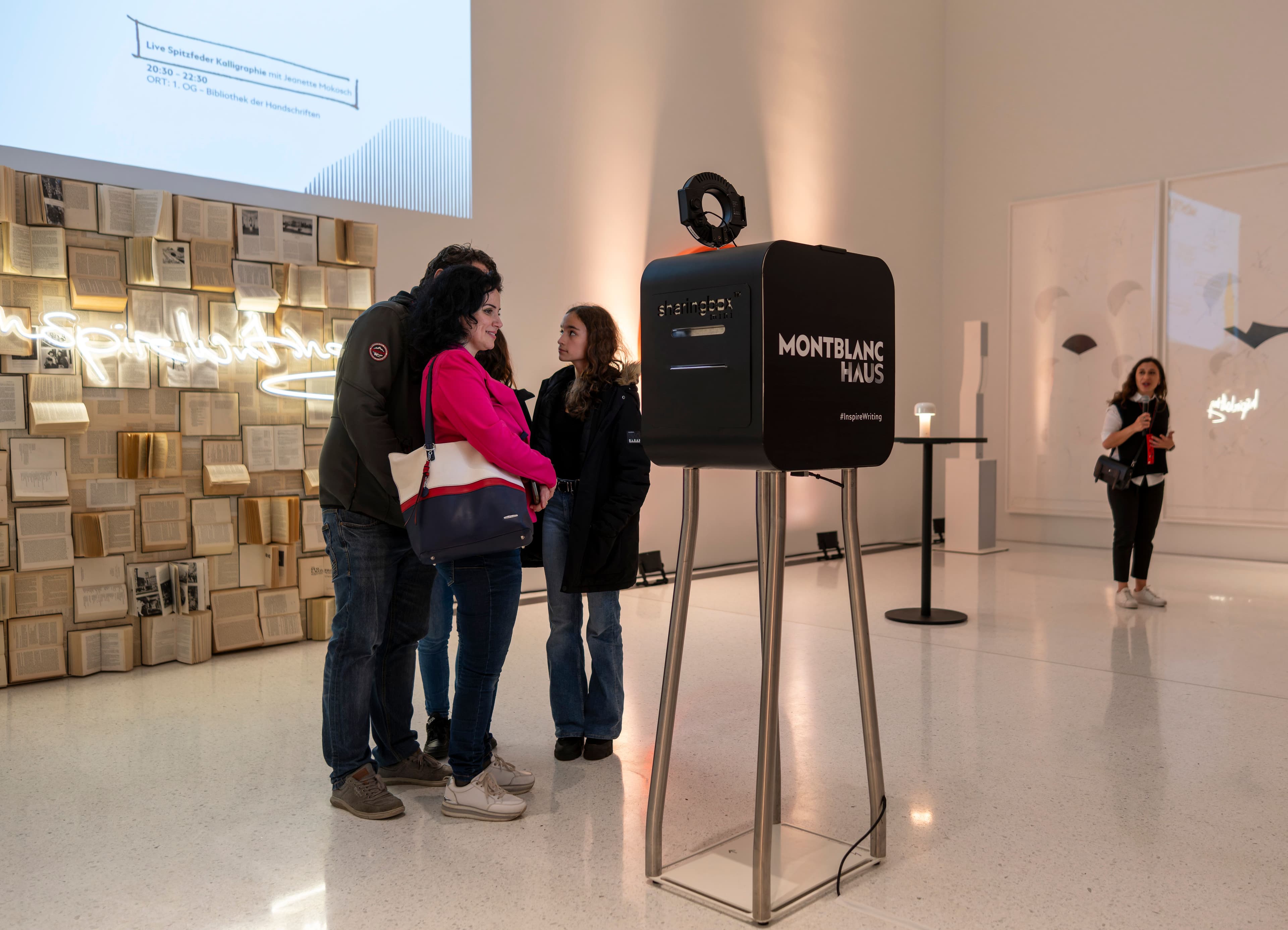 Menschen betrachten Bilder einer Ausstellung.