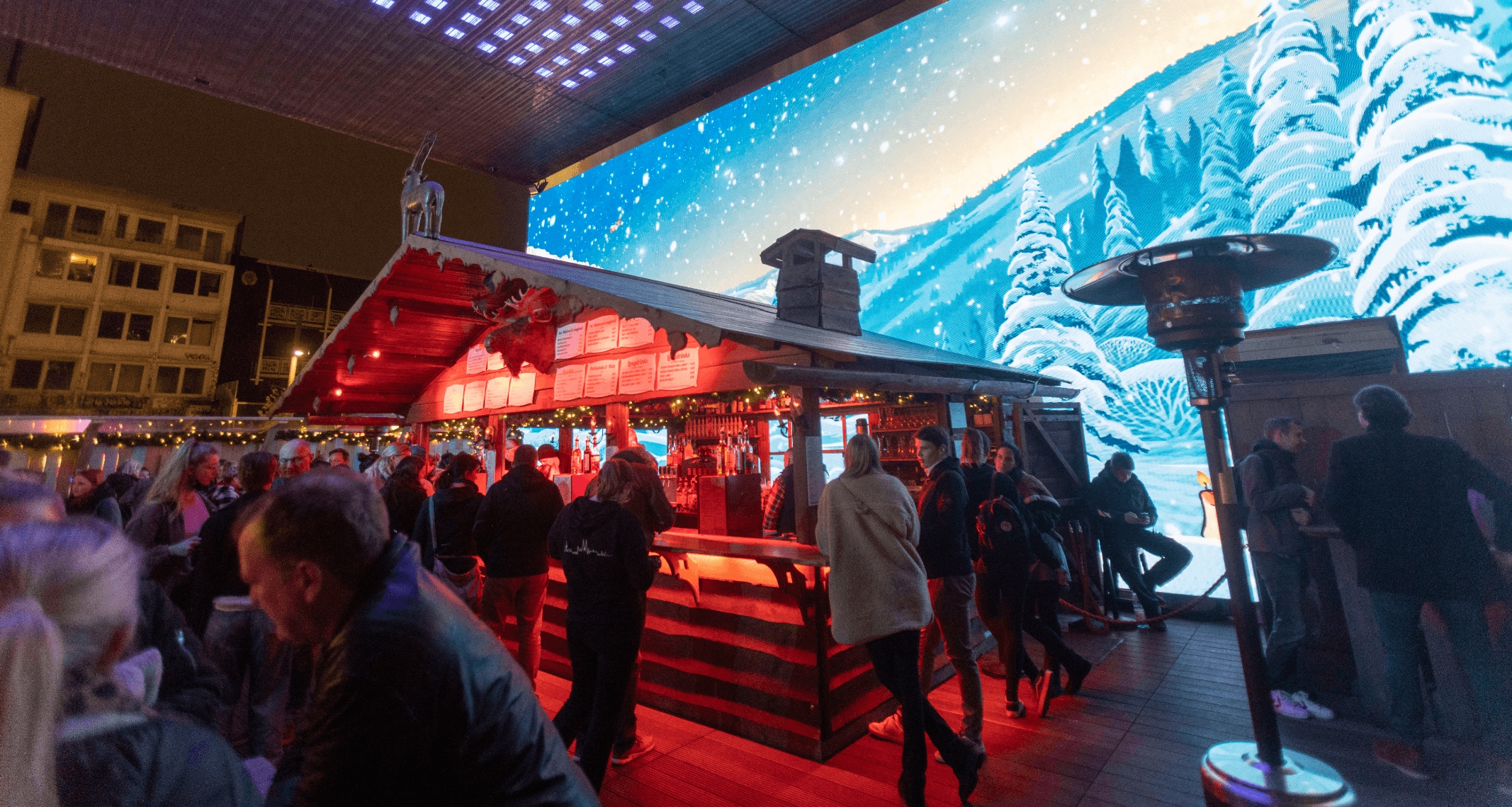 Menschen stehen auf dem Winterdeck auf dem Spielbudenplatz an einer Hütte