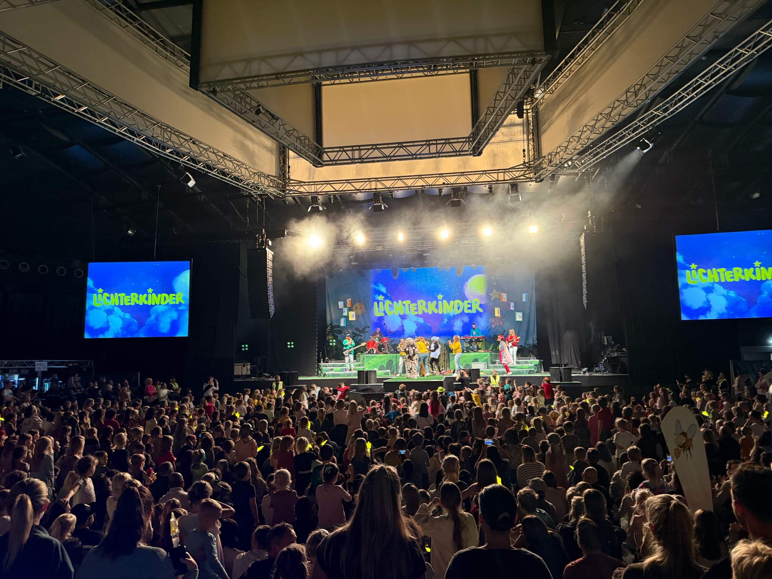Die Lichterkinder performen vor einem großen Publikum auf einer Bühne