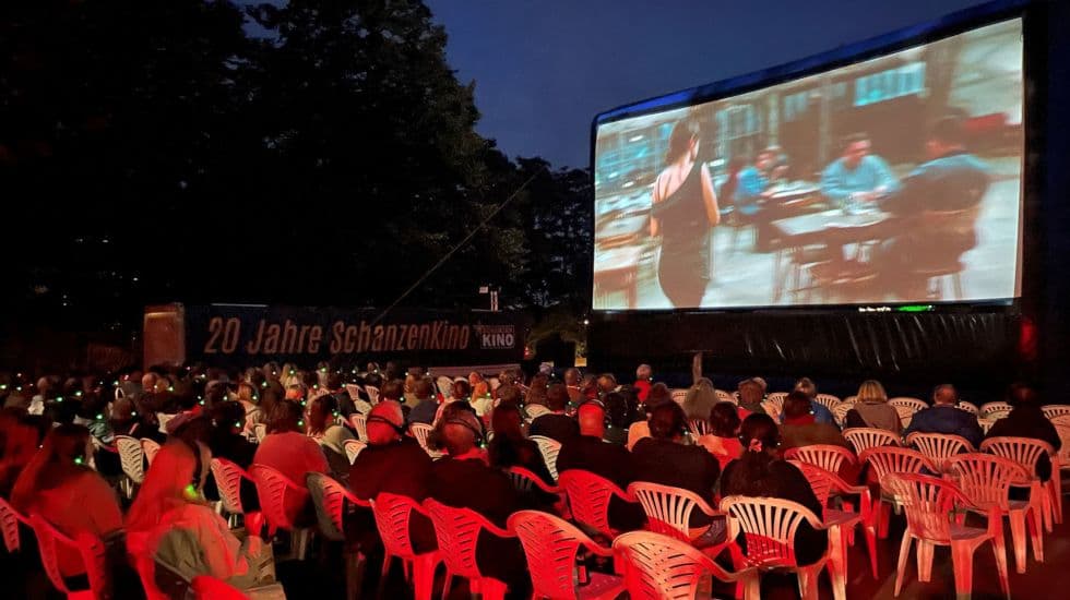 Personen beim Open-Air-Schanzen Kino auf Plastikstühlen